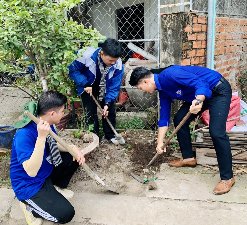 Diễn viên Lê Minh Thành - Đại sứ của chiến dịch “Thanh niên tình nguyện hè” tỉnh Bến Tre (bìa phải) tham gia làm phần việc thanh niên cùng các chiến sĩ tình nguyện.