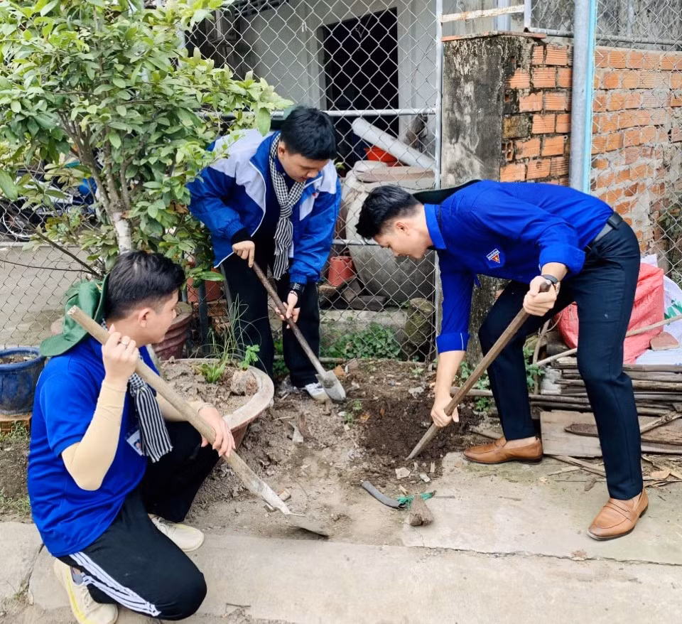 Diễn viên Lê Minh Thành - Đại sứ của chiến dịch “Thanh niên tình nguyện hè” tỉnh Bến Tre (bìa phải) tham gia làm phần việc thanh niên cùng các chiến sĩ tình nguyện.