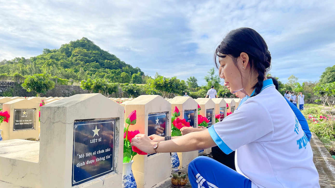 Bạn trẻ thay hoa tại các mộ liệt sĩ.