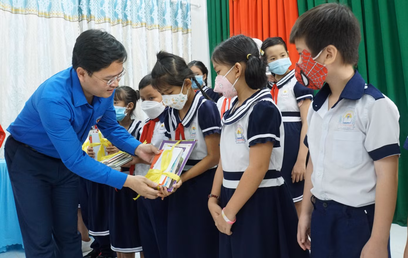 Bí thư thứ nhất Trung ương Đoàn Nguyễn Anh Tuấn tặng quà cho học sinh trường tiểu học Thiên Hộ Dương. - Ảnh: Hòa Hội