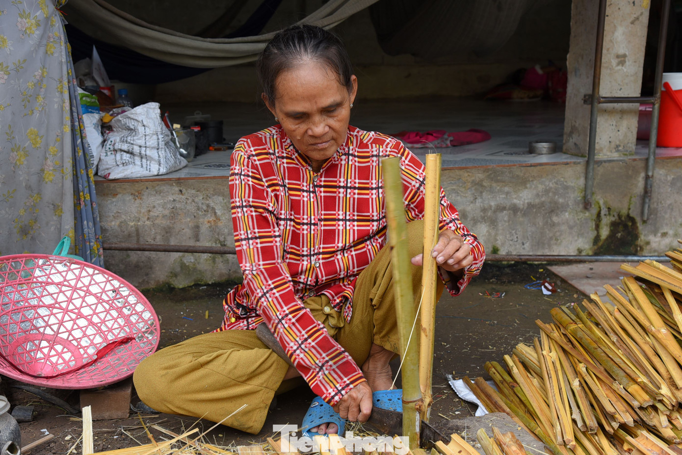 Vợ ông Đỉnh phụ chẻ tre làm lọp. Ảnh: Hòa Hội.