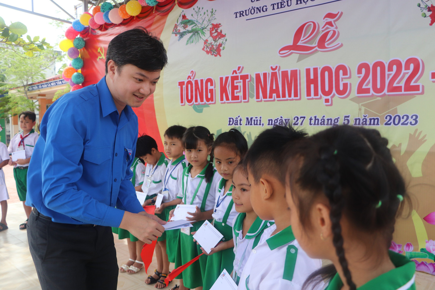 Anh Nguyễn Minh Triết tặng quà cho học sinh tại trường TH 3 Đất Mũi. Ảnh: An Bình.