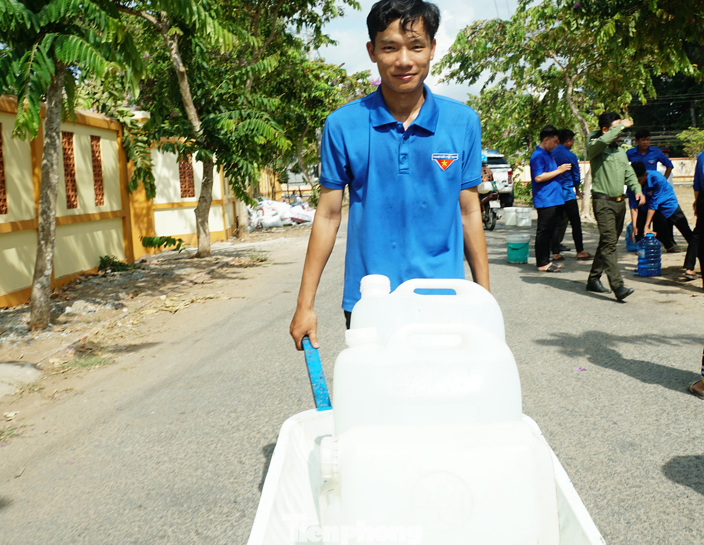 Đoàn viên thanh niên đẩy xe chở nước đến tận nhà giúp người dân tại huyện Ba Tri. Ảnh: Hòa Hội