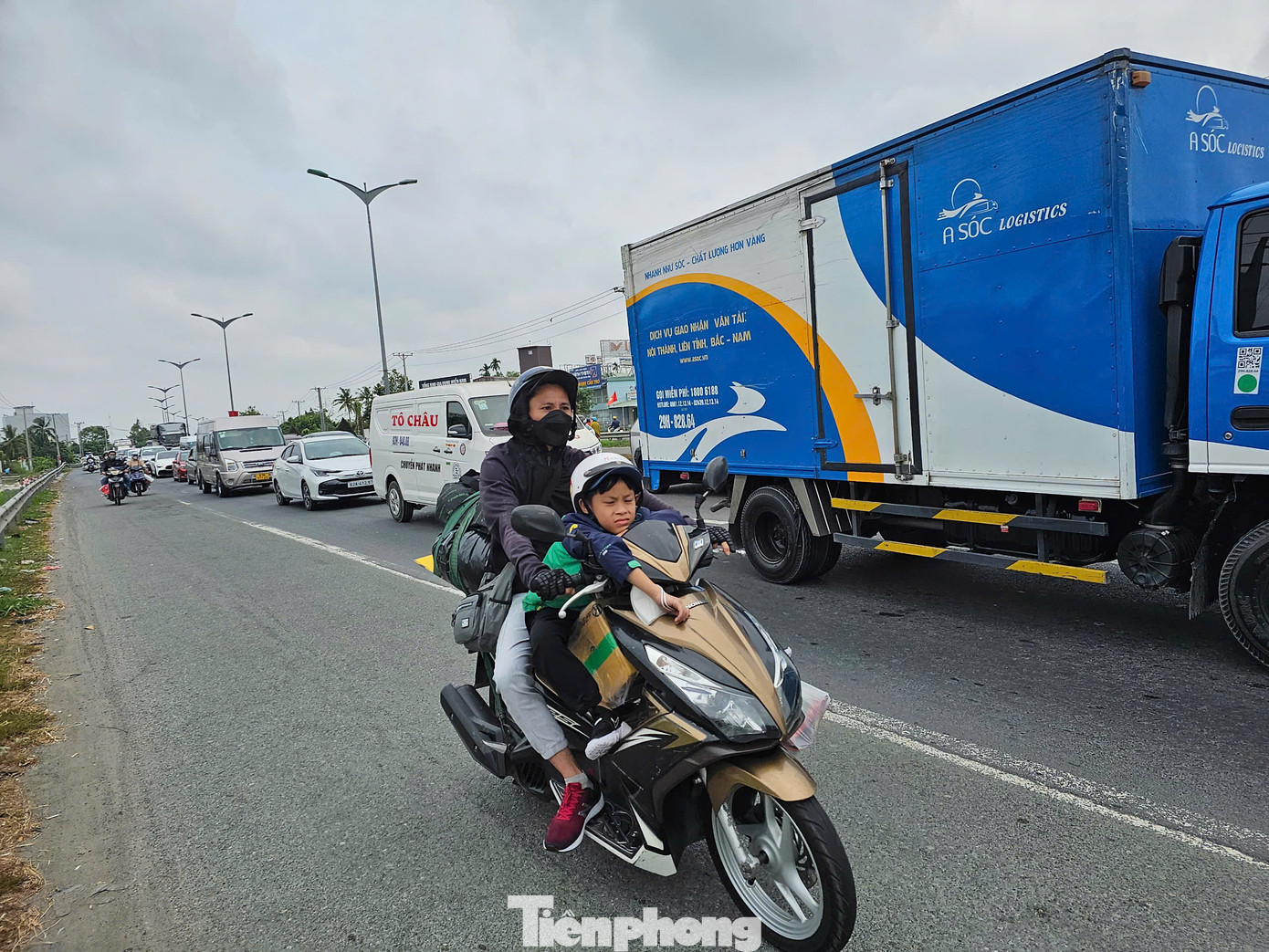 Trẻ em mệt mỏi trên xe gắn máy. Ảnh: Hòa Hội