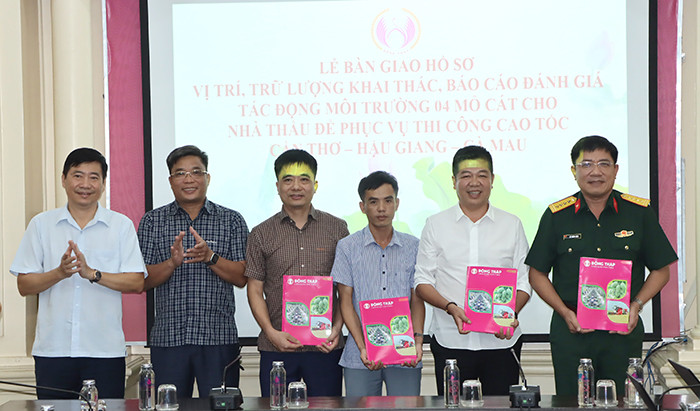 Chủ tịch UBND tỉnh Đồng Tháp Phạm Thiện Nghĩa (bìa trái) trao hồ sơ 4 mỏ cát cho các nhà thầu. Ảnh: V. Tiến.