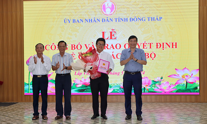 Chủ tịch UBND tỉnh Đồng Tháp Phạm Thiện Nghĩa (bìa phải) trao quyết định, chúc mừng ông Lê Lam Minh Nhật. Ảnh:. V. Tiến