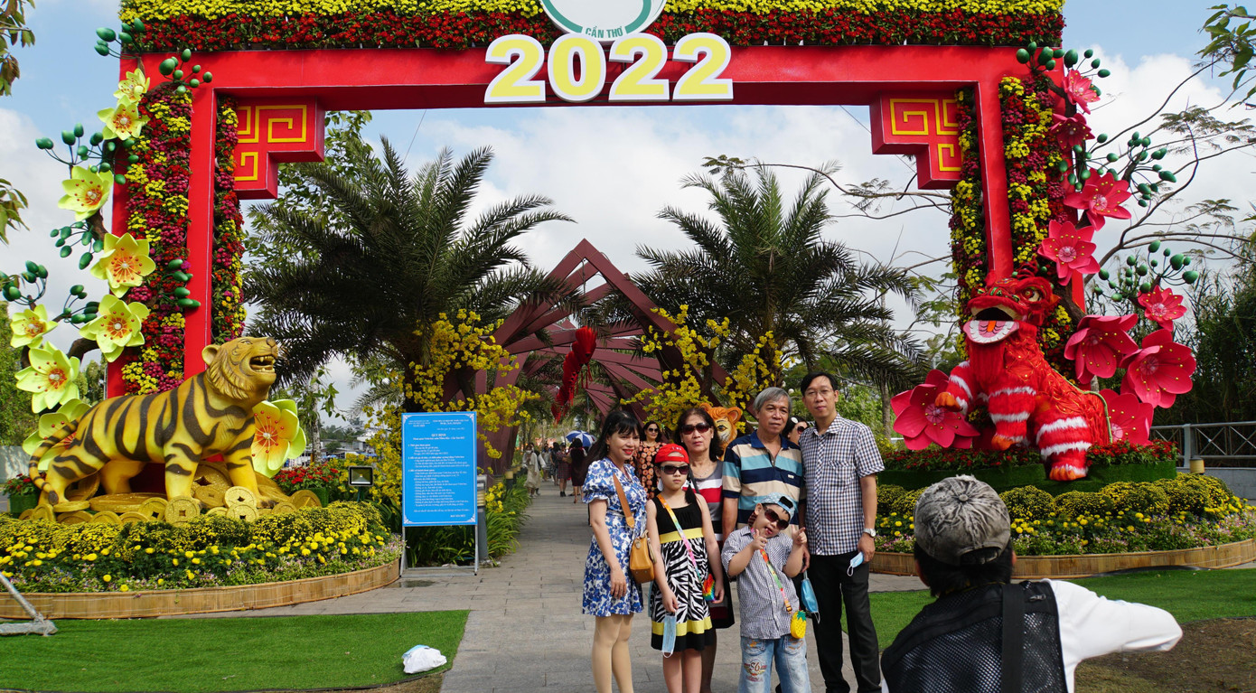 Gia đình chụp ảnh làm kỷ niệm trước cổng Vườn hoa xuân. - Ảnh: Hòa Hội