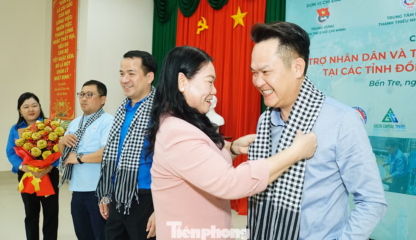 Bà Nguyễn Thị Bé Mười, Phó chủ tịch UBND tỉnh Bến Tre tặng khăn cho ông Đặng Hồng Anh. Ảnh: Hòa Hội