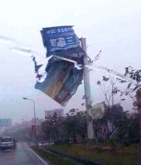 Biển quảng cáo tơi tả vì gió lớn. Ảnh: hinews.cn