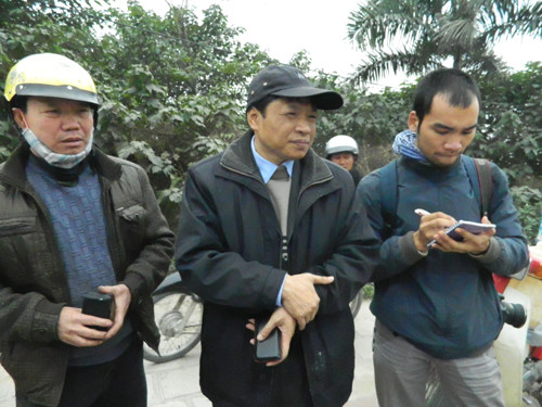 Ông Ngô Văn Linh (giữa) ngẩn ngơ trước chiếc xe Mercedes thành đống tro tàn