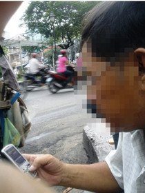 Ông H. điện thoại dắt mối cho khách (ảnh chụp ngày 24-9-2010). Ảnh: N.K. (Tuổi Trẻ)