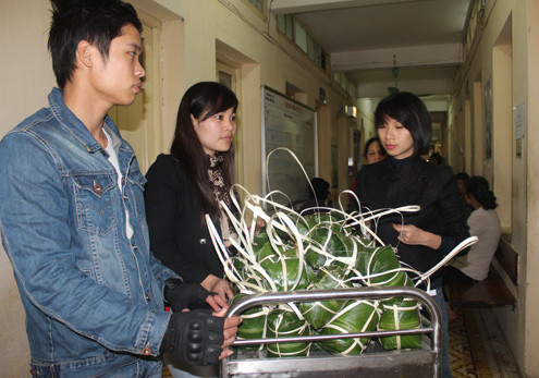 Mượn xe đẩy, các bạn trẻ chở giò mang tới từng phòng trao tận tay cho người bệnh