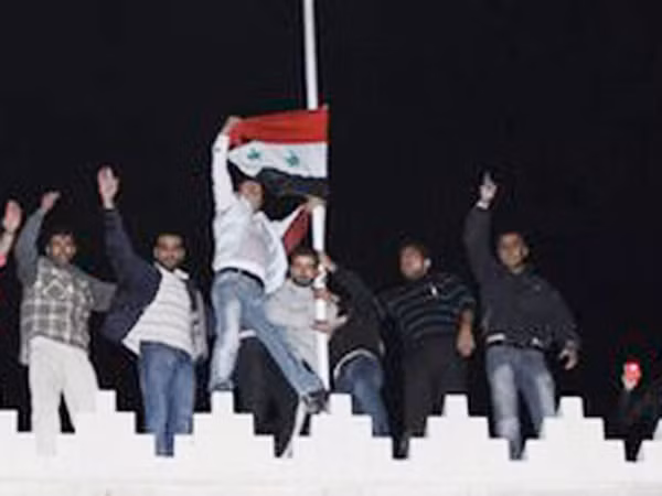 Những người ủng hộ ông Assad giương cờ Syria tại Đại sứ quán Qatar. Ảnh: Getty Images