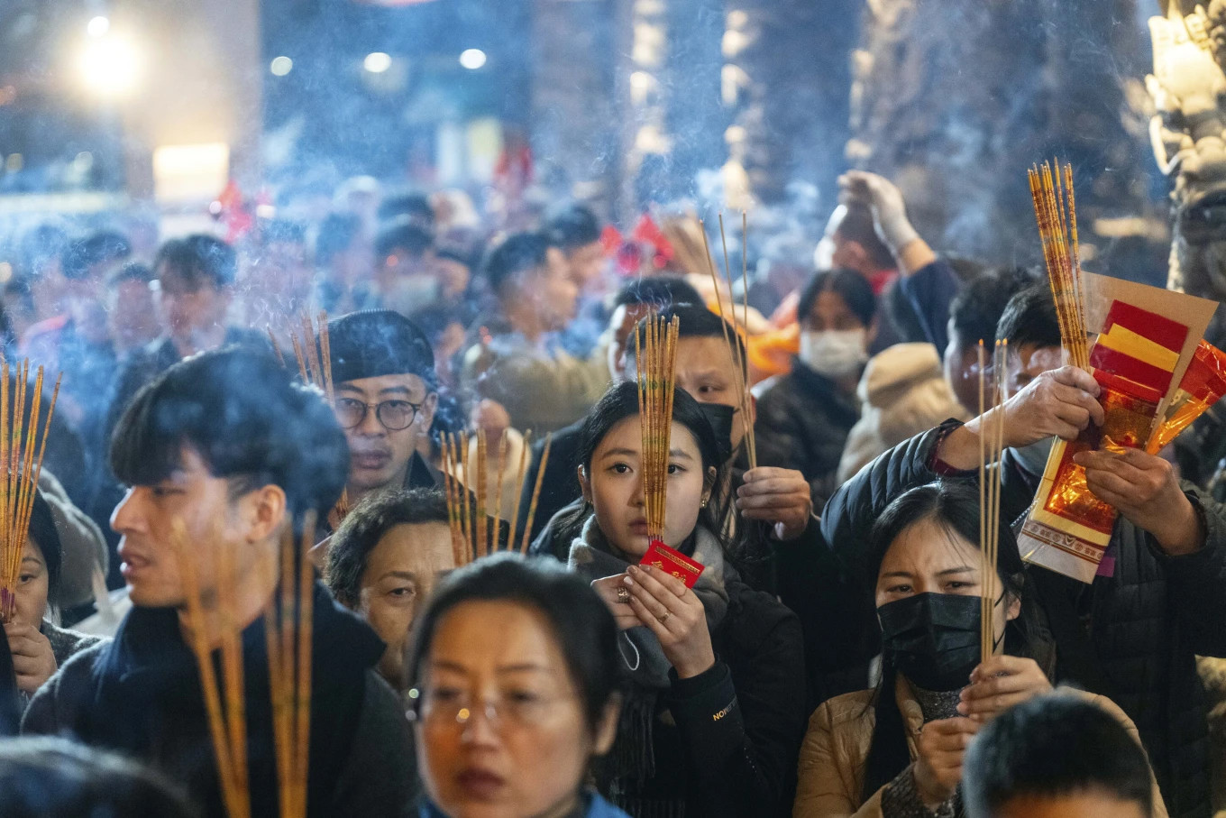 Người dân thắp hương tại đền Wong Tai Sin (Huỳnh Đại Tiên) để chào đón Tết Nguyên đán Ất Tỵ ở Hong Kong - Trung Quốc. Ảnh: AP.