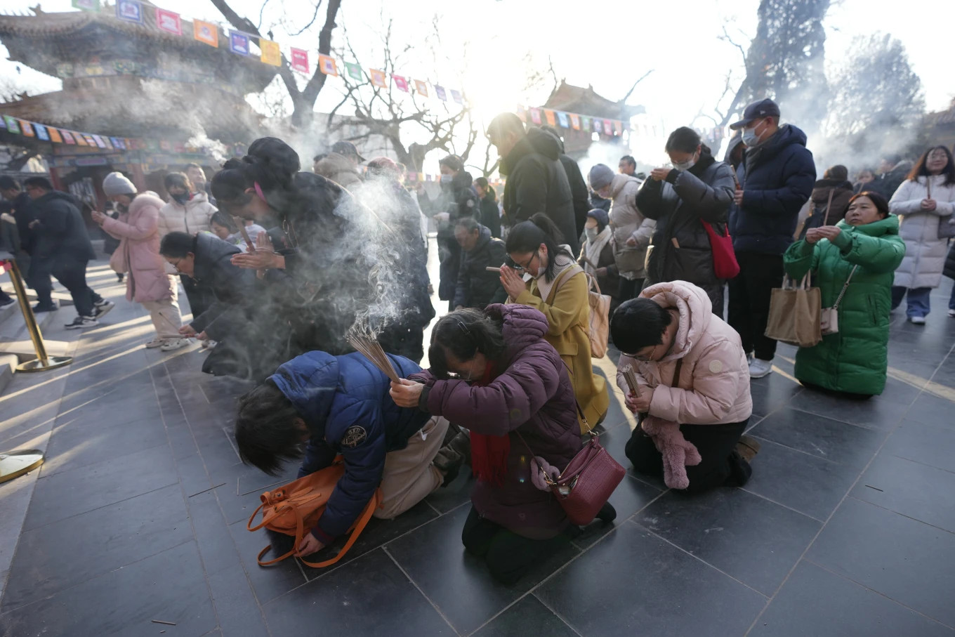 Cảnh tượng mọi người thắp hương và khấn vái dịp Tết Nguyên tại đền Lama (Ung Hòa Cung) - chùa Phật giáo Tây Tạng ở Bắc Kinh. Niu Qingshan, người đến Ung Hòa Cung từ tỉnh Hà Bắc cho biết: "Chúng tôi muốn loại bỏ mọi điều xấu và bệnh tật của năm cũ và chào đón năm mới". Ảnh: AP.