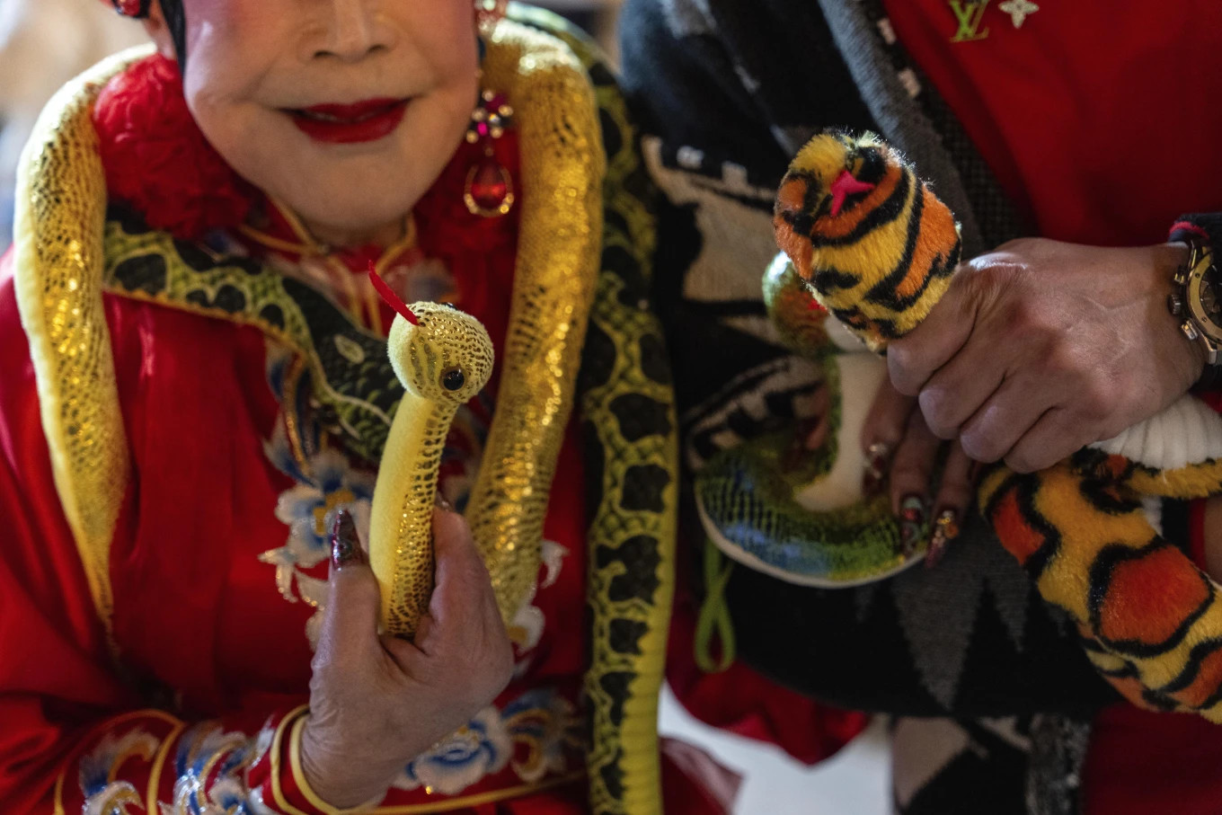 Nghệ nhân Lana Wong Wai Lin và tín đồ cầm rắn đồ chơi tại đền Huỳnh Đại Tiên để chào đón Tết Nguyên đán. Ảnh: AP.