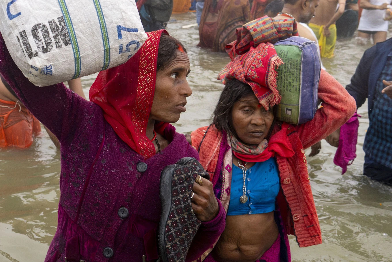 Vì sợ thất lạc đồ đạc, nhiều người hành hương mang theo đồ đạc của mình xuống nước để tắm tại nơi hợp lưu của sông Hằng, sông Yamuna và dòng sông huyền thoại Saraswati. Ảnh: AP Vì sợ thất lạc đồ đạc, nhiều người hành hương mang theo đồ đạc của mình xuống nước để tắm tại nơi hợp lưu của sông Hằng, sông Yamuna và dòng sông huyền thoại Saraswati. Ảnh: AP