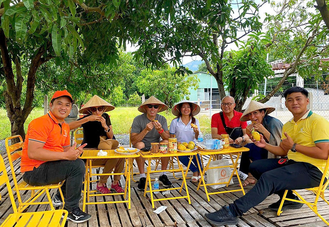 Du khách quốc tế thưởng thức sản phẩm từ xoài tại một vườn xoài người dân huyện Cam Lâm.