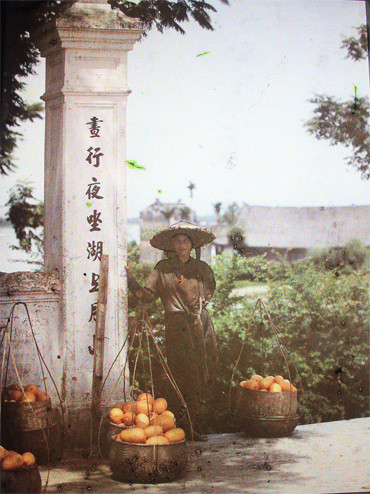  Người đứng bán hoa quả trước cửa đền Ngọc Sơn