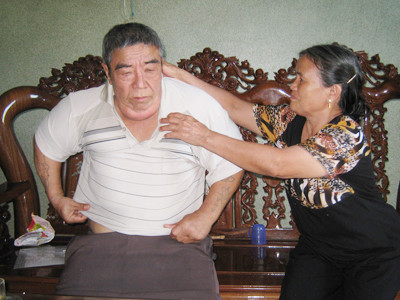 Bà Hiệp chăm sóc chồng. Ảnh: Lê Kiến
