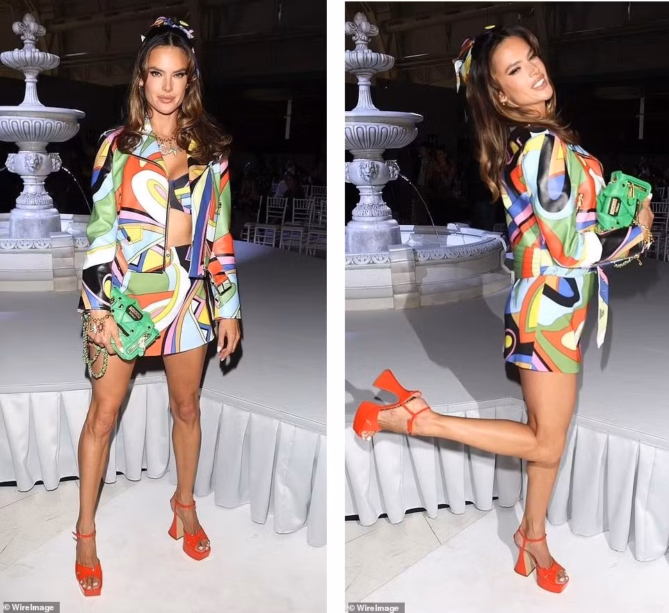 Alessandra Ambrosio nổi bật không kém đàn chị với set đồ ba món, gồm áo khoác, bra và chân váy ngắn nhiều họa tiết rực rỡ. "Chân dài" Brazil hoàn thiện vẻ ngoài thời thượng với khăn buộc tóc đồng bộ trang phục, giày cao gót đỏ và túi xách xanh lá. Ảnh: Wire Images.
