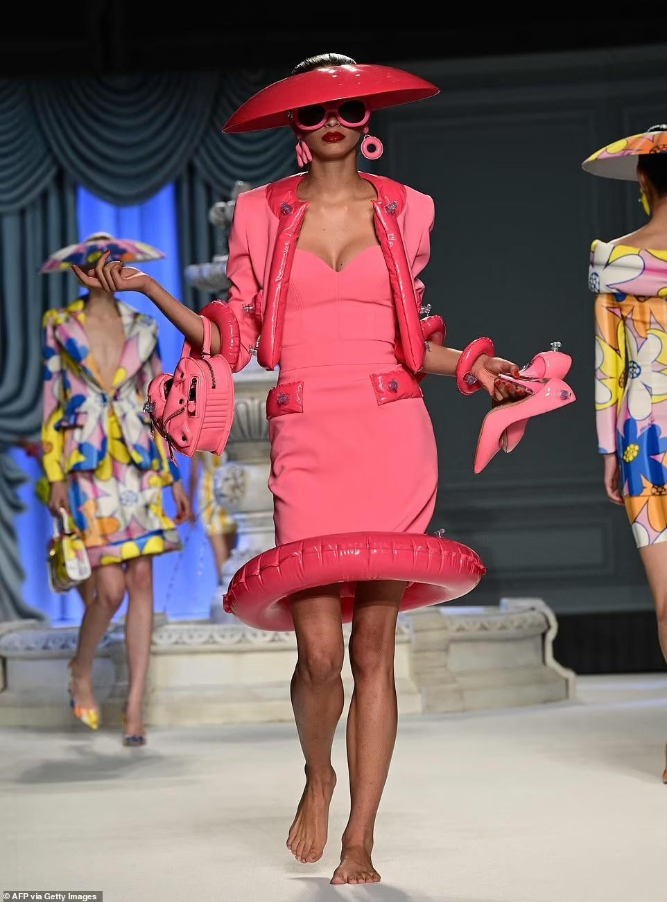 Bộ sưu tập mới của Moschino kết hợp các mẫu váy áo kiểu dáng thanh lịch, lady với yếu tố gợi nhớ tuổi thơ như họa tiết hoạt hình, bóng hơi, phao hình động vật... Ảnh: Getty Images.