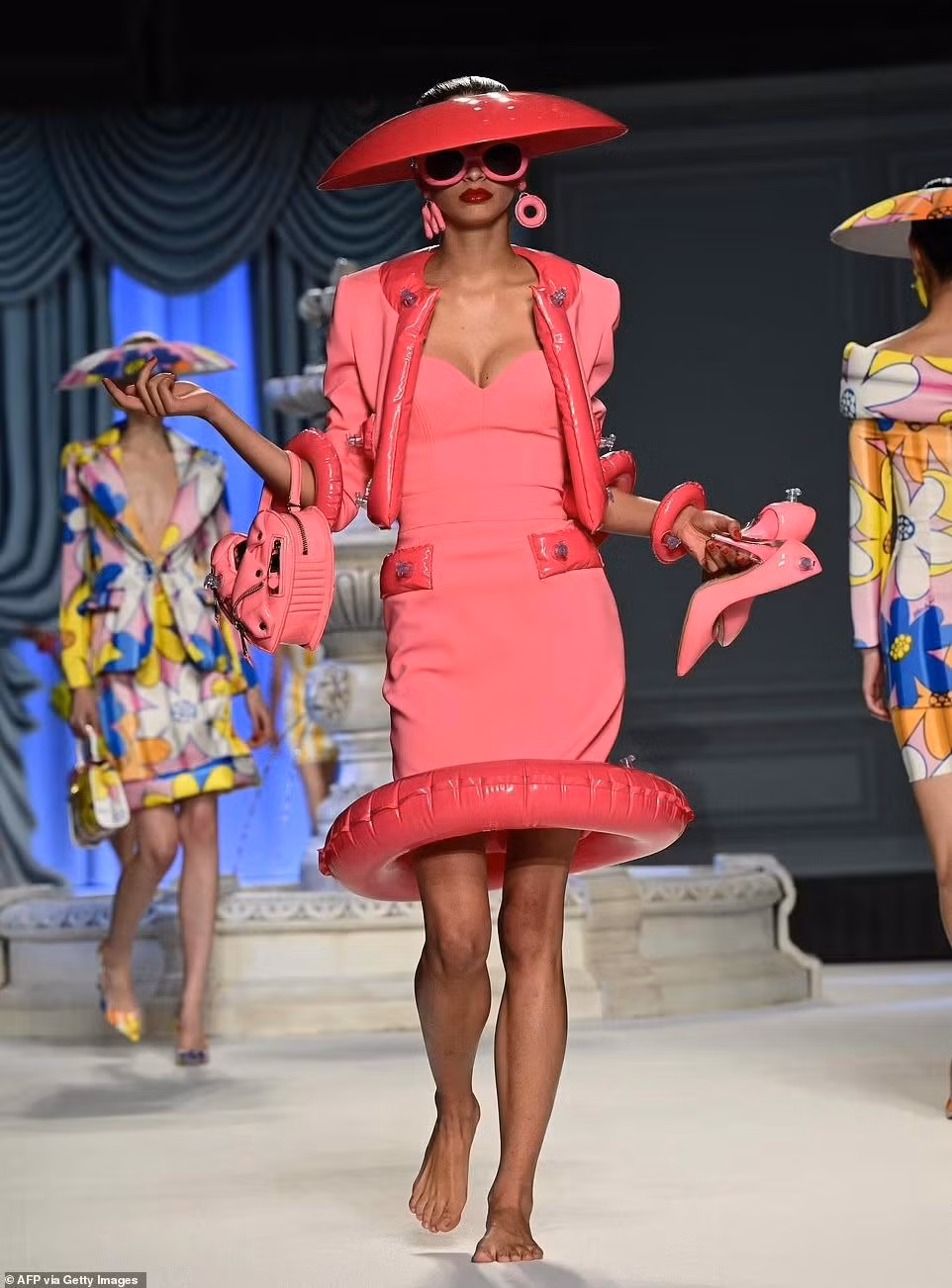 Bộ sưu tập mới của Moschino kết hợp các mẫu váy áo kiểu dáng thanh lịch, lady với yếu tố gợi nhớ tuổi thơ như họa tiết hoạt hình, bóng hơi, phao hình động vật... Ảnh: Getty Images.