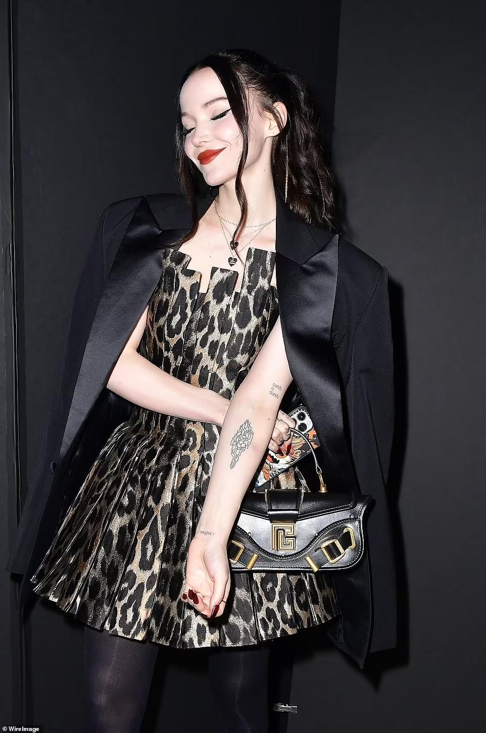 Ca sĩ người Mỹ Dove Cameron mặc một chiếc váy mini họa tiết da báo và áo blazer đen toát lên vẻ kiêu kỳ, tiểu thư.