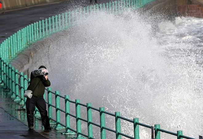 Người đàn ông này trang bị dụng cụ bảo vệ máy ảnh rất cẩn thận để ghi hình sóng. Ảnh: AP
