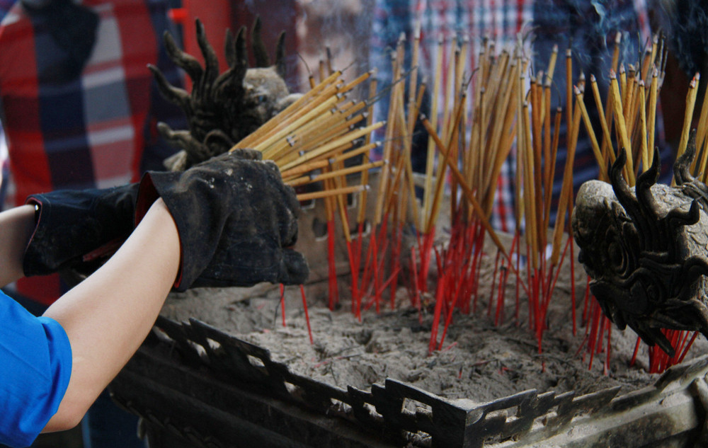 Một số sinh viên tình nguyện phải đi nhổ bớt hương do phụ huynh, sĩ tử thắp quá nhiều. Ảnh: Trường Phong