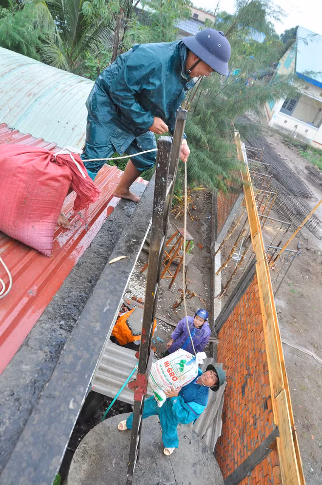 Dân quân tự vệ dầm mưa chằng chống nhà cửa chống bão ảnh 3