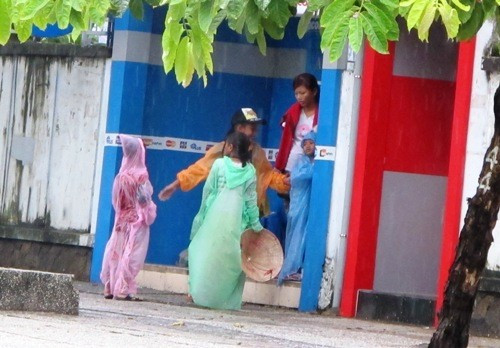 Mang tiền về cho thiếu nữ mặc áo đỏ đứng trong trụ ATM gần đó