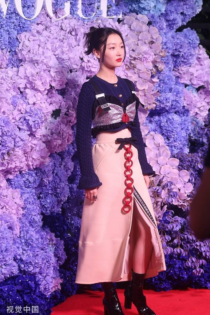 Châu Đông Vũ kết hợp áo len crop-top xanh và chân váy màu be xẻ tà ở giữa. Set đồ bị chê vì nhiều chi tiết thừa.