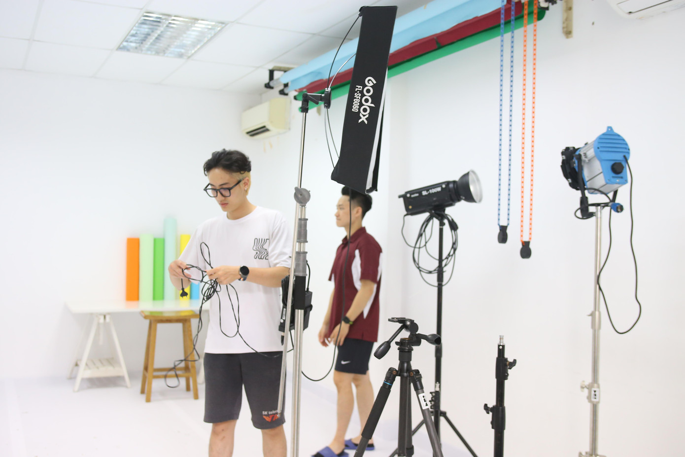 Chàng trai chuẩn bị thiết bị cho buổi quay ngắn tại studio công ty.