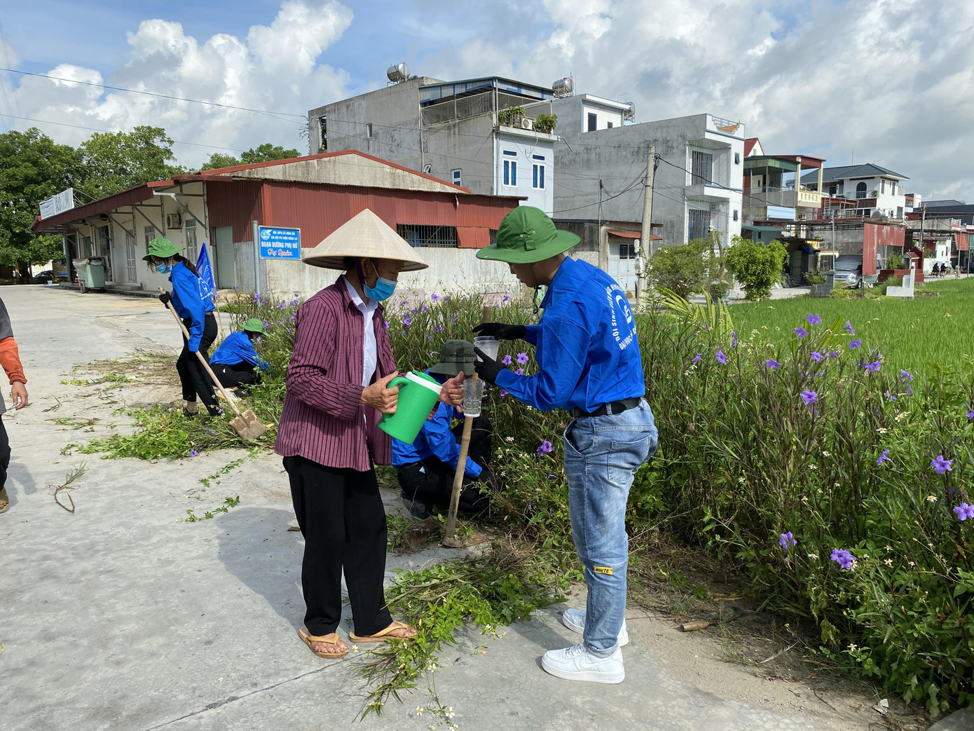 Hoạt động dọn dẹp, vệ sinh đường làng của đội sinh viên tình nguyện.
