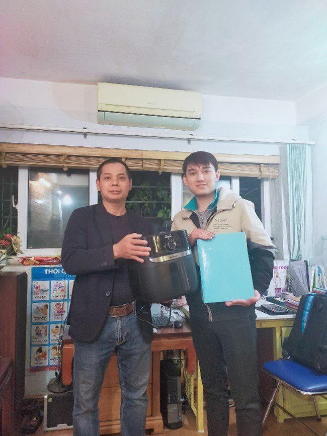 Chụp ảnh cùng khách hàng trong buổi trao hợp đồng bảo hiểm và quà tặng cho khách.