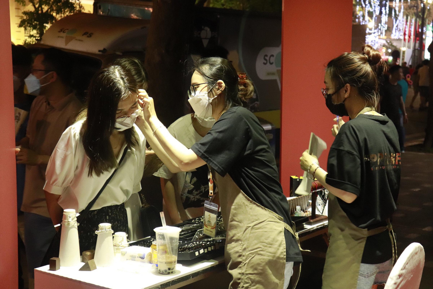 Các bạn trẻ thích thú và trải nghiệm đeo khuyên.