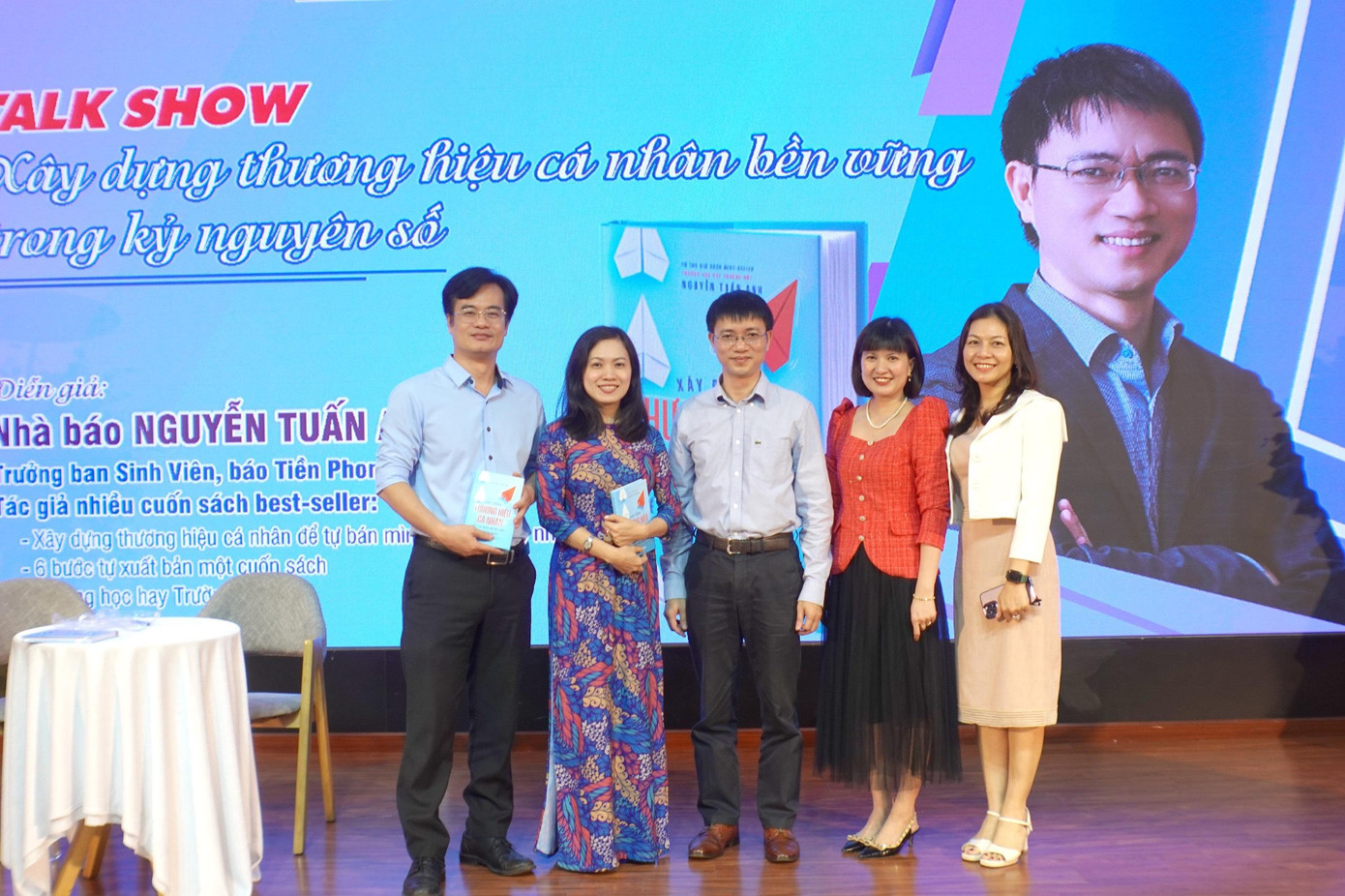 Tiến sĩ Huỳnh Ngọc Mai Kha (mặc áo dài) – Phó Hiệu trưởng Trường Đại học Ngoại ngữ - Đại học Đà Nẵng chụp ảnh lưu niệm cùng diễn giả, tác giả, nhà báo Nguyễn Tuấn Anh (đứng giữa); Thạc sĩ Đinh Mỹ Hạnh (ngoài cùng bên phải) – Trưởng ban Công tác Học sinh Sinh Viên, Đại học Đà Nẵng; Thạc sĩ Nguyễn Thái Trung – Trưởng phòng Công tác sinh viên, Trường Đại học Ngoại ngữ (ngoài cùng bên trái); Tiến sĩ Nguyễn Phương Khánh - Giảng viên Trường Đại học Sư phạm.