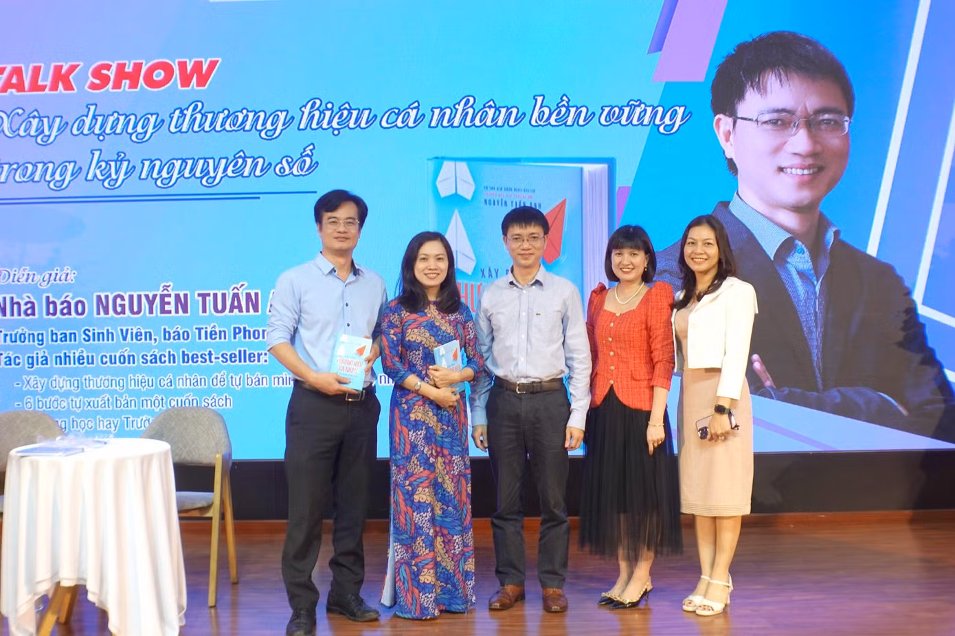 Tiến sĩ Huỳnh Ngọc Mai Kha (mặc áo dài) – Phó Hiệu trưởng Trường Đại học Ngoại ngữ - Đại học Đà Nẵng chụp ảnh lưu niệm cùng diễn giả, tác giả, nhà báo Nguyễn Tuấn Anh (đứng giữa); Thạc sĩ Đinh Mỹ Hạnh (ngoài cùng bên phải) – Trưởng ban Công tác Học sinh Sinh Viên, Đại học Đà Nẵng; Thạc sĩ Nguyễn Thái Trung – Trưởng phòng Công tác sinh viên, Trường Đại học Ngoại ngữ (ngoài cùng bên trái); Tiến sĩ Nguyễn Phương Khánh - Giảng viên Trường Đại học Sư phạm.