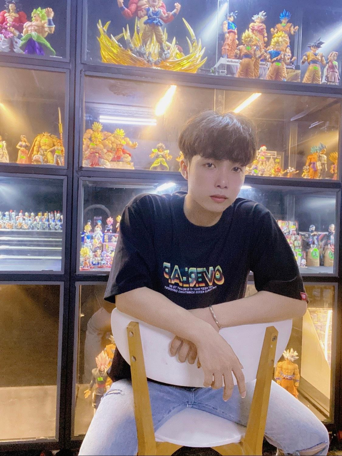 Hoàng Định bên những mô hình nhân vật được sưu tầm.