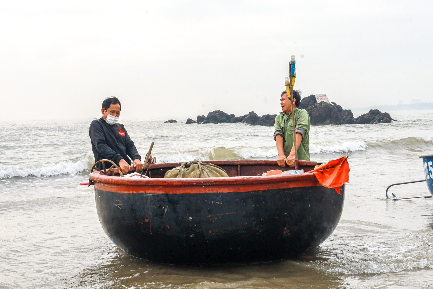 Ngư dân miệt mài kéo thúng vào bờ để trở về nhà sau chuyến ra khơi.
