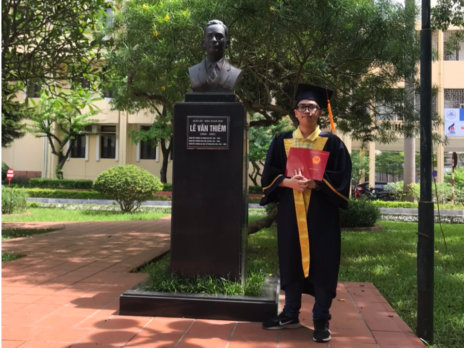 Việt Dũng chụp tại khuôn viên trường ĐH Sư phạm Hà Nội trong ngày tốt nghiệp, cùng tượng của Giáo sư Lê Văn Thiêm - tiến sĩ Toán học đầu tiên của Việt Nam.