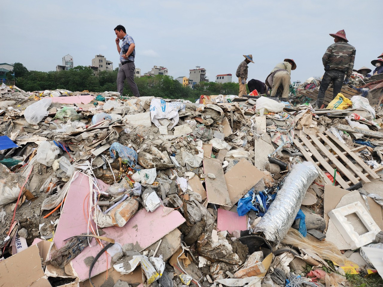 Công nhân làm việc trên tuyến đường ven sông Đáy đắp bằng trạc thải xây dựng tại xã Cộng Hòa