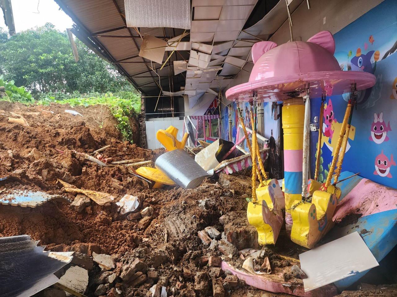 Đất đá xen lẫn các vật dụng trong khu vui chơi.