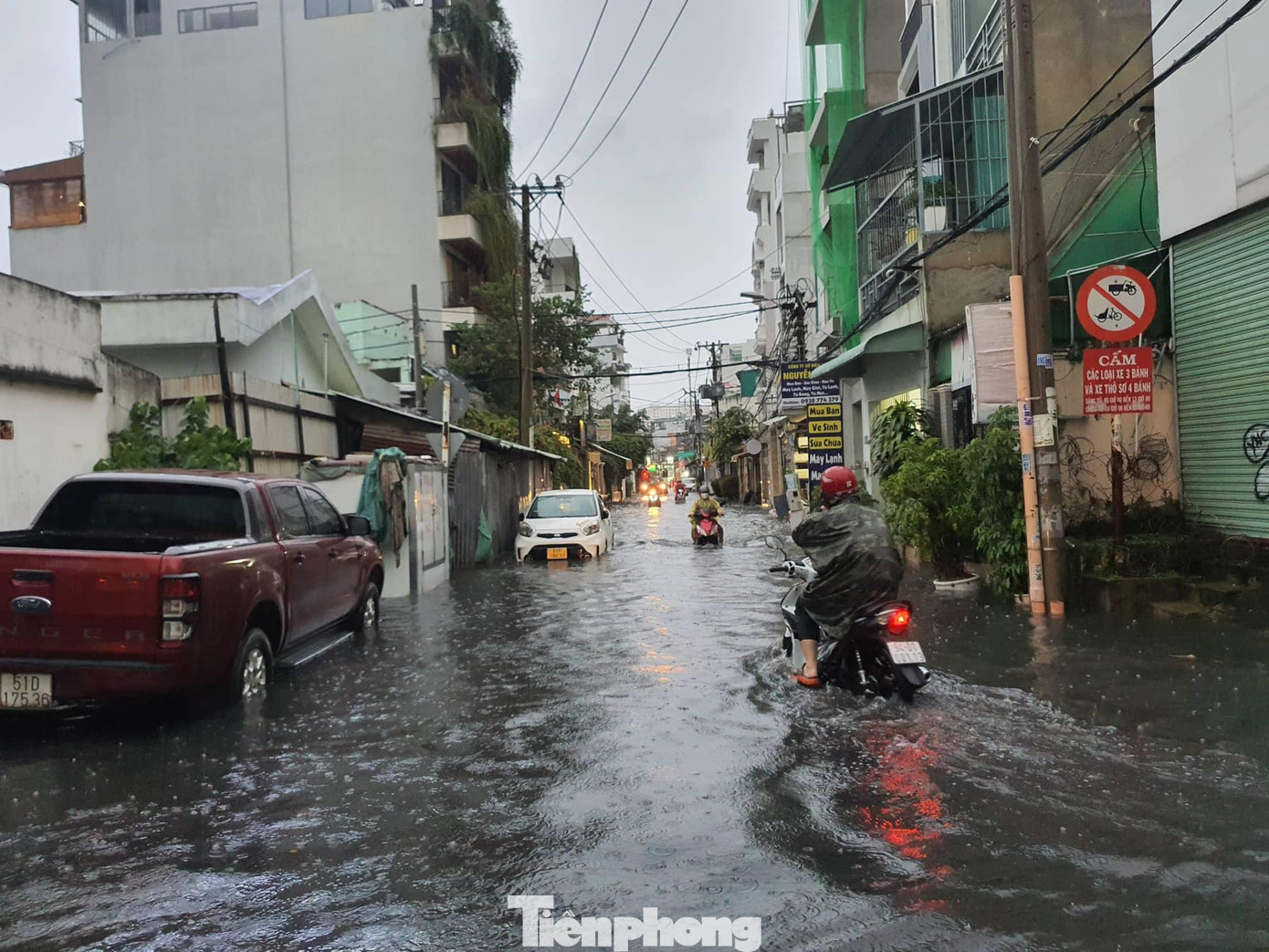 Nước ngập gần lút bánh xe máy khiến người dân gặp rất nhiều khó khăn khi di chuyển.