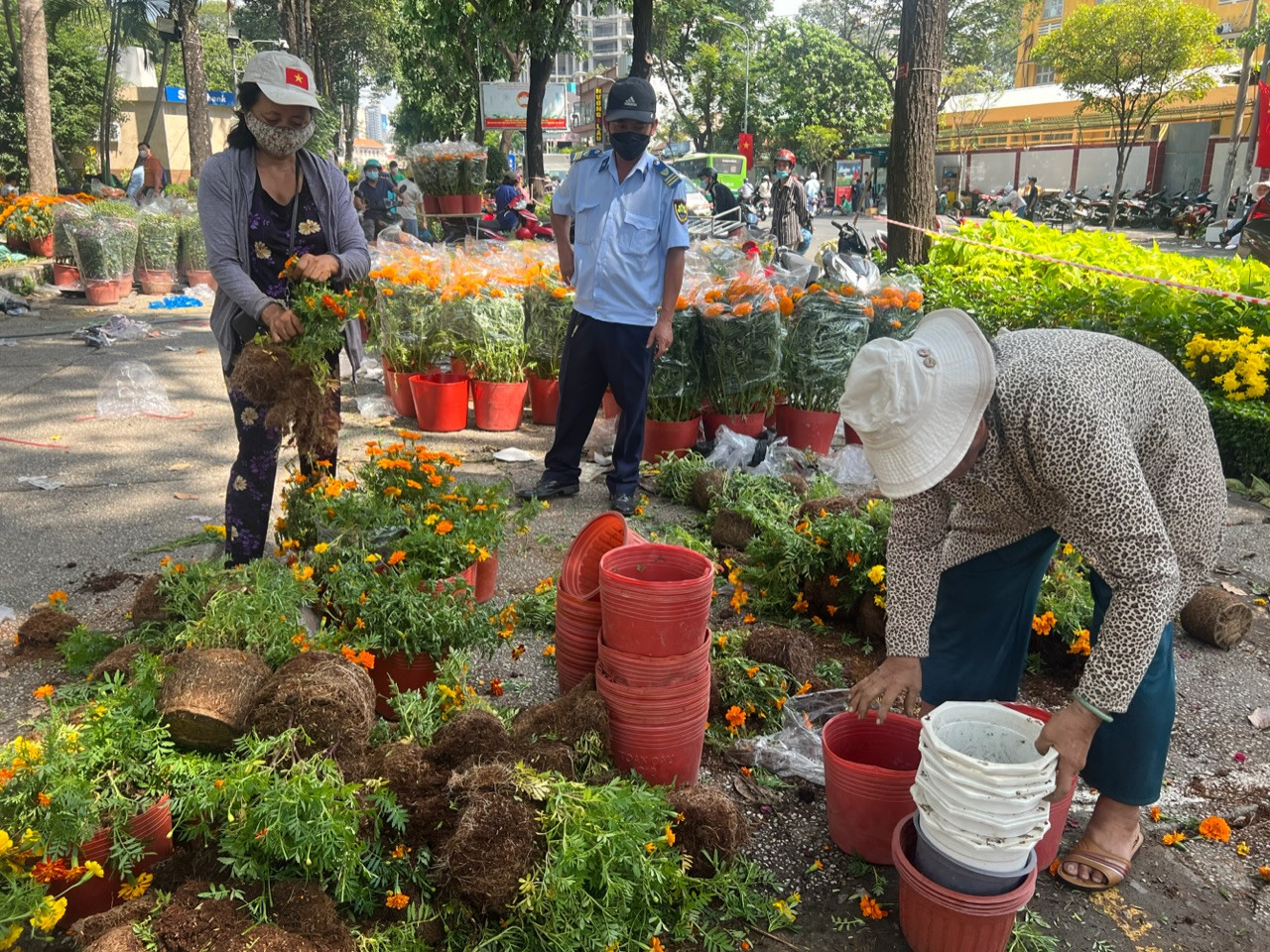 Hoa bị phá bỏ, tiểu thương chỉ lấy lại chậu. Hoa nằm ngổn ngang trên mặt đất.