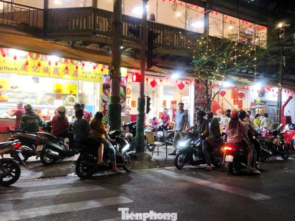 Một quán cơm gà ở góc đường Trần Hưng Đạo - Ngô Quyền (quận 5), khách đứng tràn dưới lòng đường chờ bàn hoặc mua mang về vì quán đã kín chỗ. "Chúng tôi chờ hơn 30 phút mới mua được phần cơm gà xối mỡ khách đặt qua ứng dụng. Đa số hàng quán bán Tết đều quá tải nên phải chờ đợi rất lâu" - anh Bình, nhân viên giao thức ăn công nghệ nói.