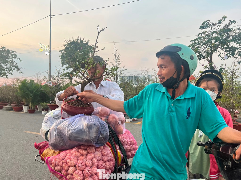 Tại chợ hoa này, khách hàng phần lớn là người lao động. Chậu mai vàng này chỉ có giá 300.000 đồng. "Hoa ở đây giá mềm nên mình tranh thủ vừa chở hàng, vừa mua thêm chậu mai chơi Tết cho vui cửa vui nhà" - một khách hàng chia sẻ.