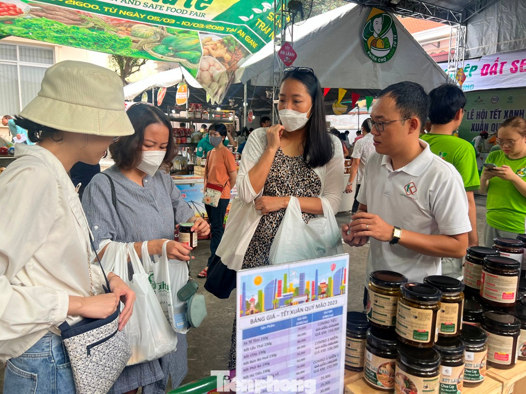 Anh Văn Long (bìa phải) nhiệt tình giới thiệu các loại xốt gia vị đến các khách hàng nữ Anh Văn Long (bìa phải) nhiệt tình giới thiệu các loại xốt gia vị đến các khách hàng nữ