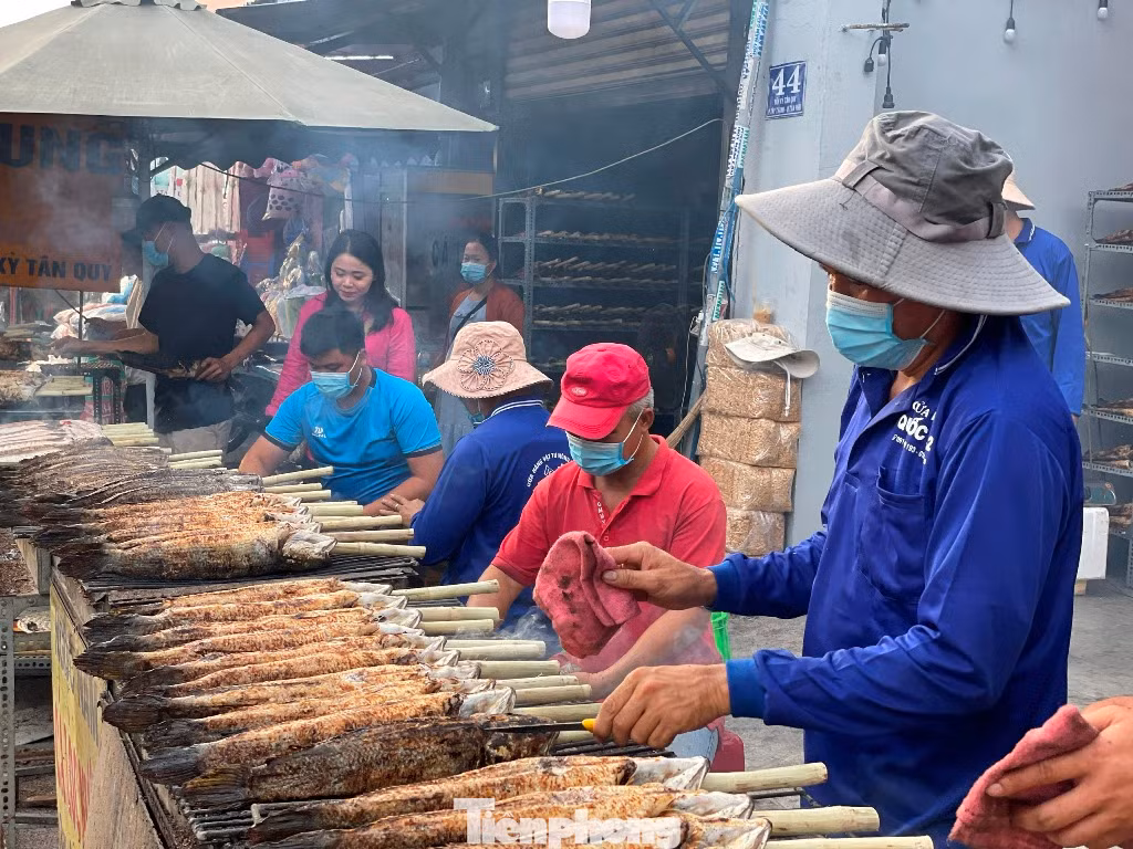 Sáng sớm nay, trên đường Tân Kỳ Tân Quý (quận Tân Phú) đã thơm nức mùi cá lóc nướng. Hơn chục hộ bán cá lóc nướng tại đây bày những con cá lóc nướng mía ngay sát mặt đường để khách dễ chọn mua.